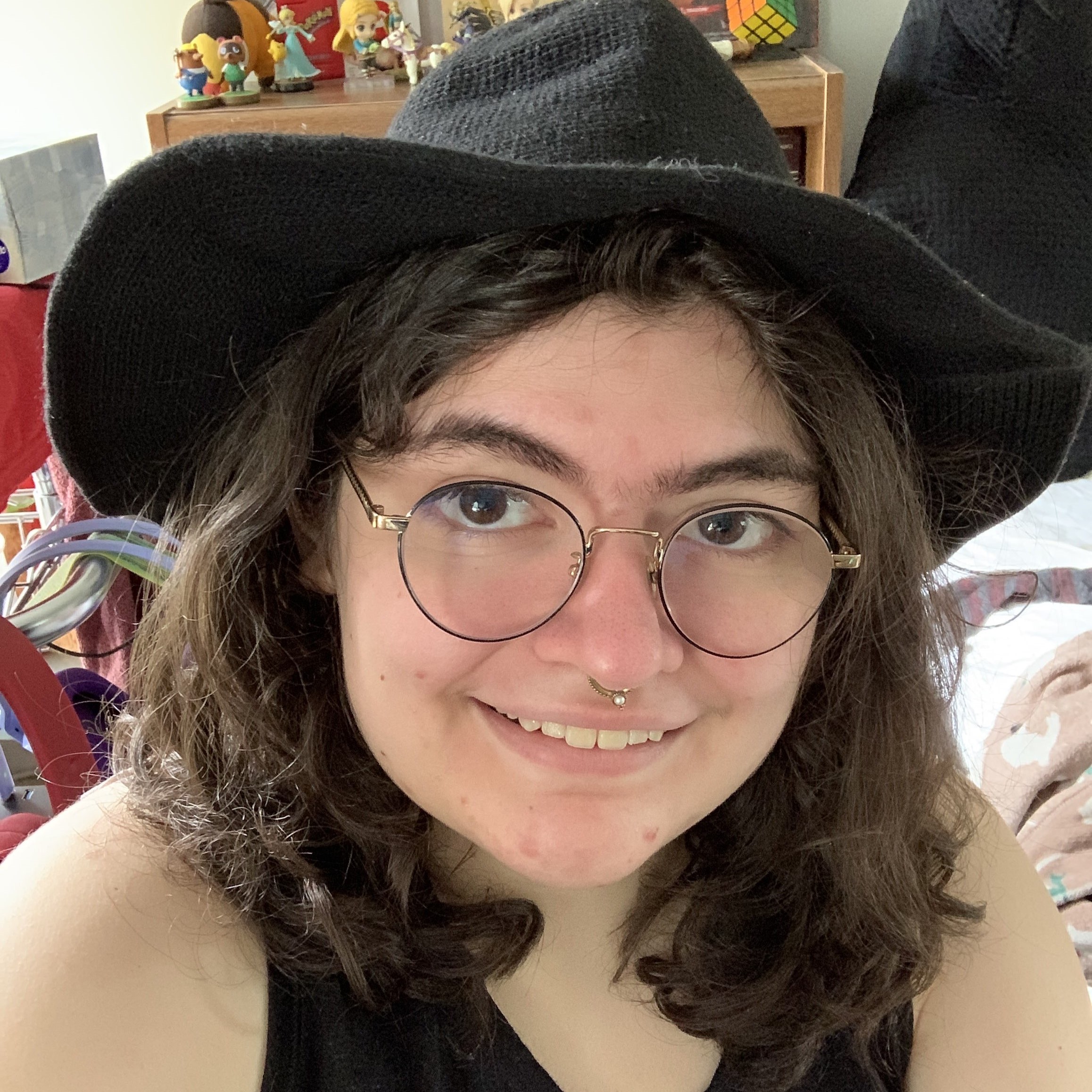 photo of Madison Chazo, a smiling woman with brown hair in glasses and a witch hat